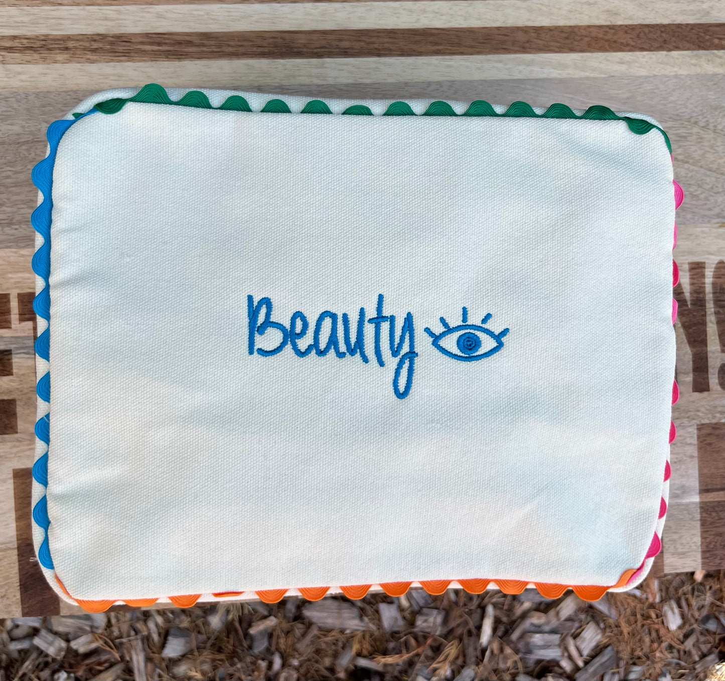 Embroidered canvas cosmetic bag with ric-rac border