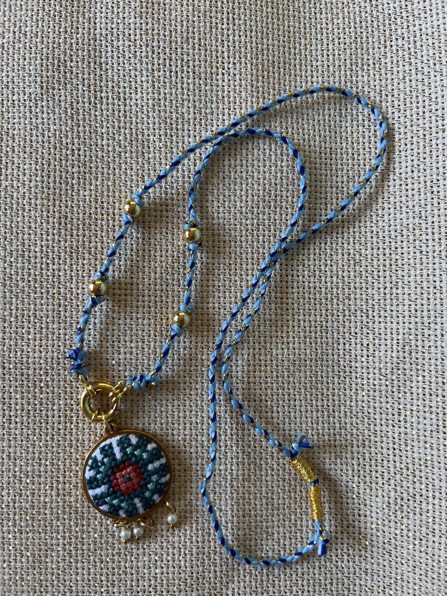 Hand embroidered cross stitch pendant and knotted necklace - geometric flower