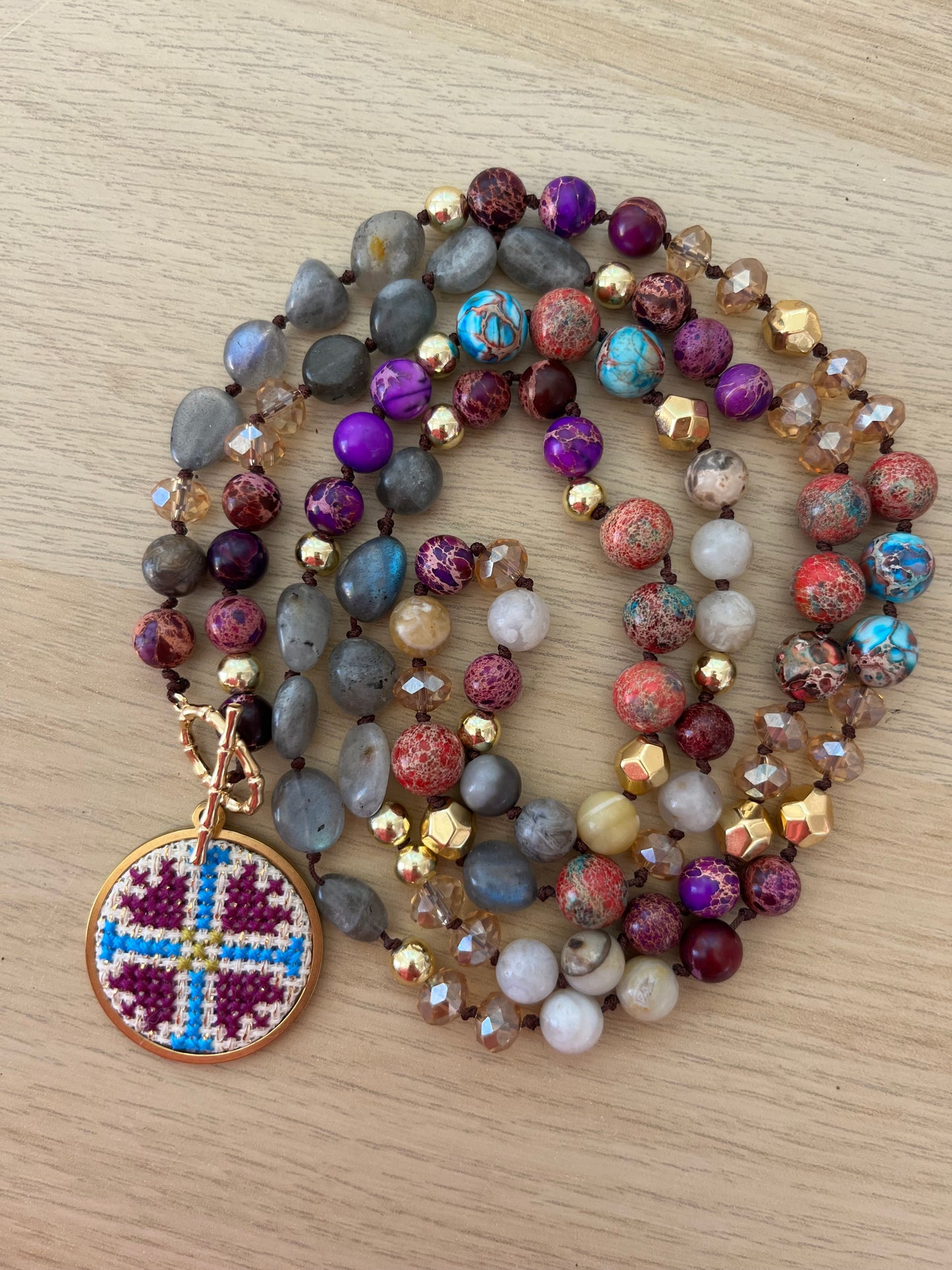 Hand embroidered cross stitch pendant and natural jasper and labradorite.