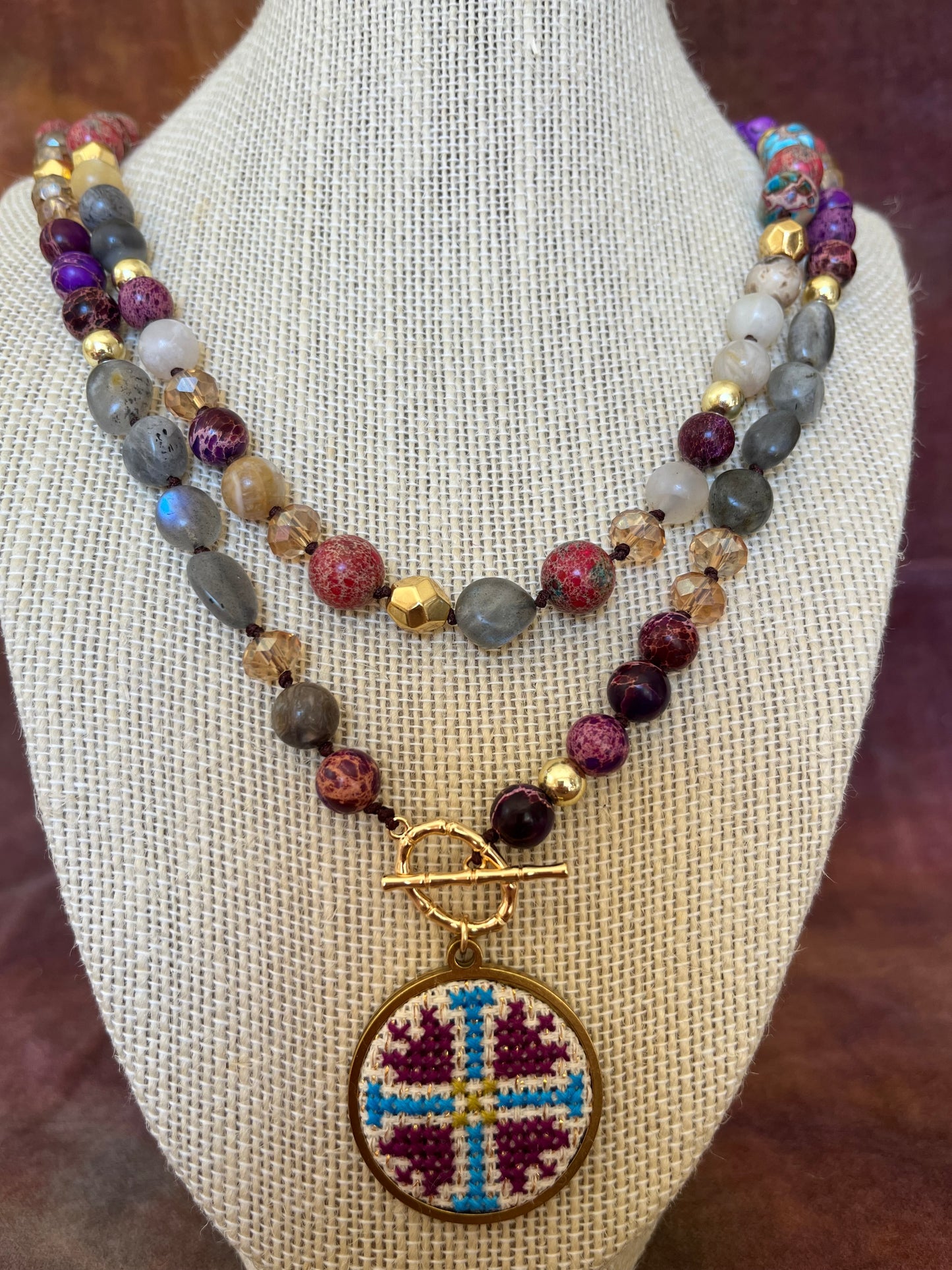 Hand embroidered cross stitch pendant and natural jasper and labradorite.
